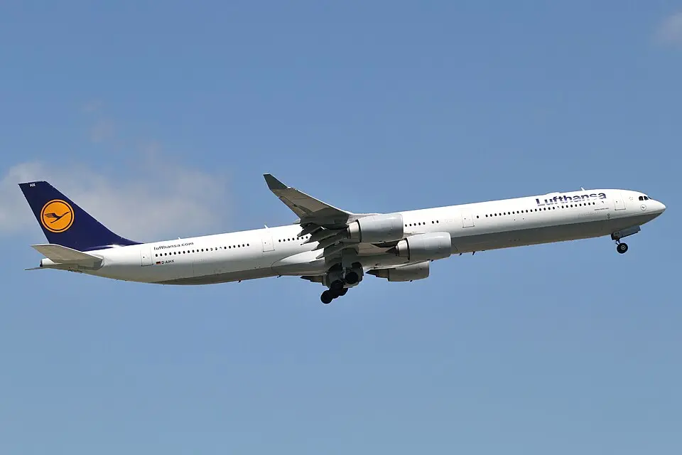 A Lufthansa Airbus A340-600, registration D-AIHR, climbing with the landing gear still down.